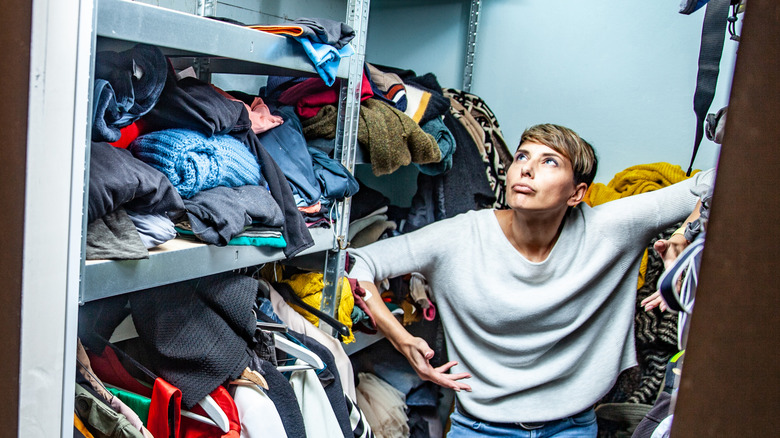 woman annoyed with cluttered closet