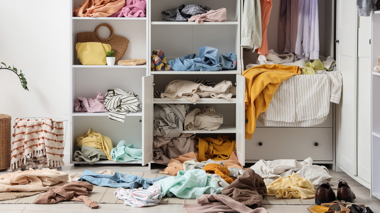 Cluttered closet with clothes scattered around