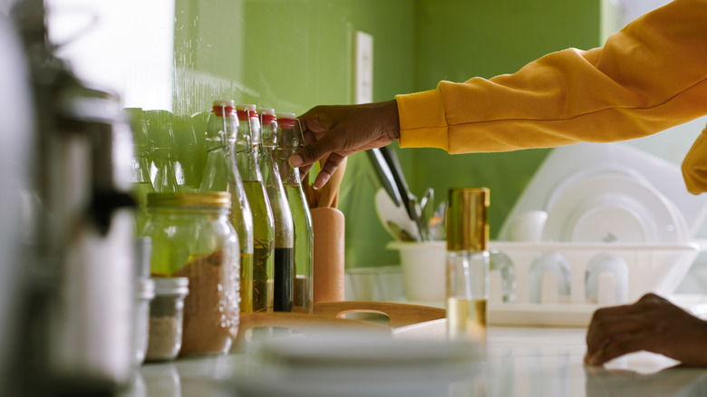 A person organizing kitchen essentials on a countertop