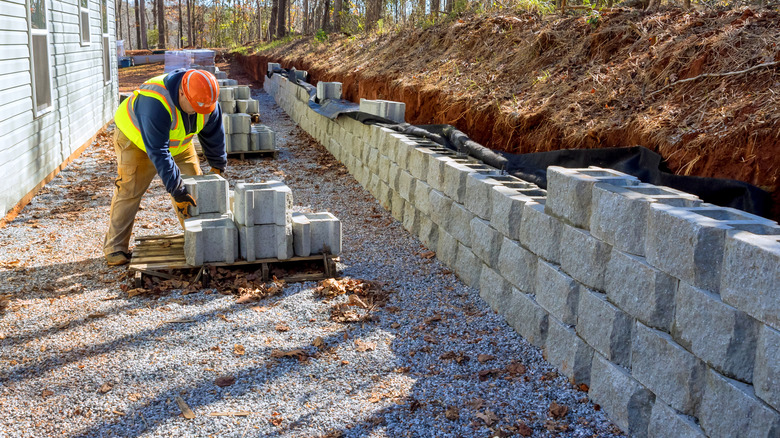 Man building a concrete block retaining wall