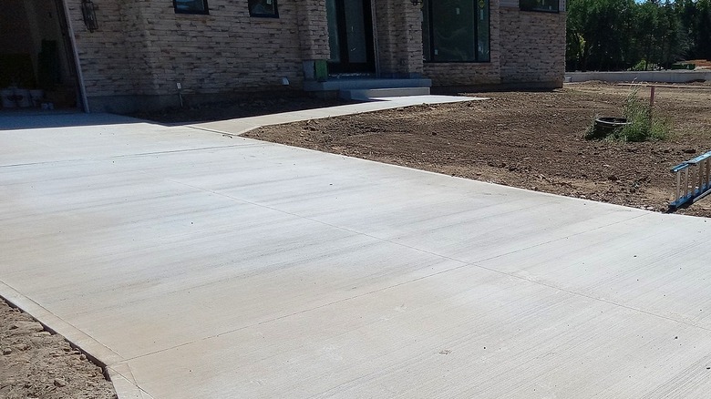 New concrete driveway installation and a front yard of only dirt