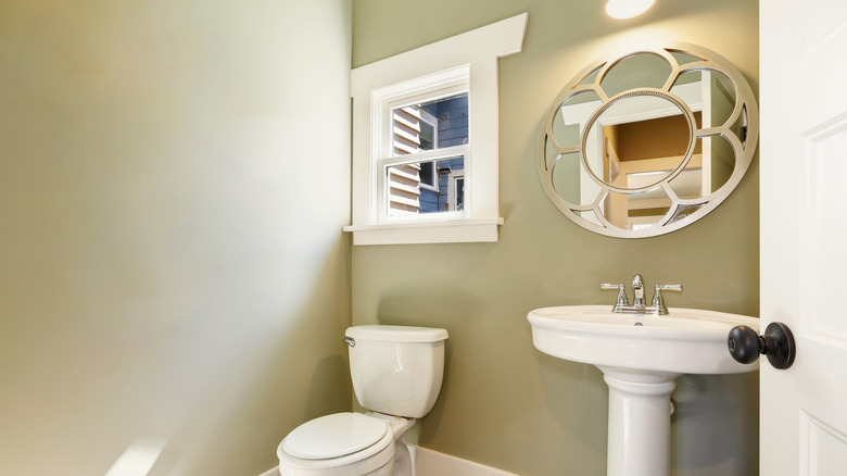 Basic green bathroom with white door and trim
