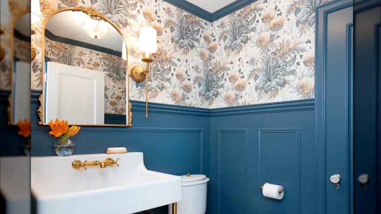 updated powder room with vintage wallpaper and deep blue trim and paneling