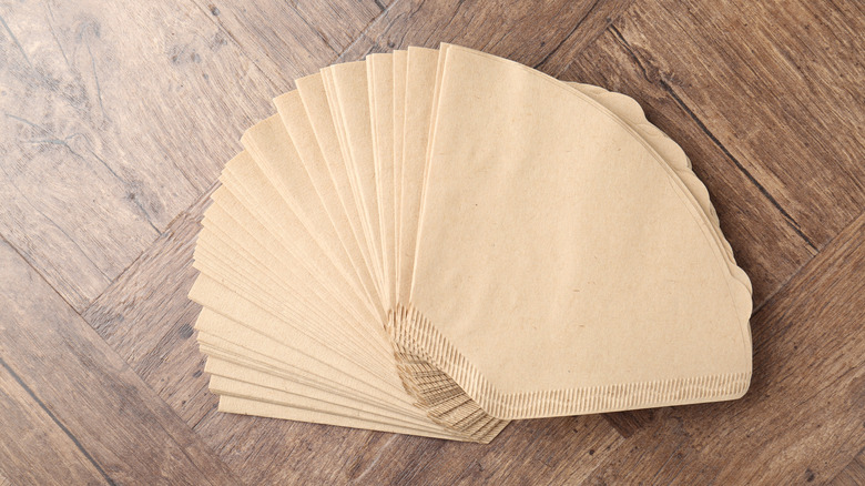 A stack of coffee filters on a wood surface