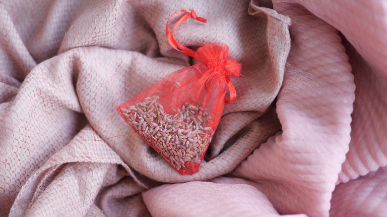 A pink sachet filled with dried lavender sitting on a blanket
