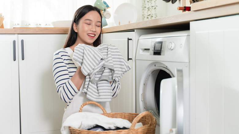 Woman smelling shirt from dryer