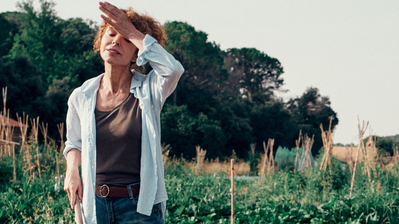 Woman working in hot garden under sweltering sun