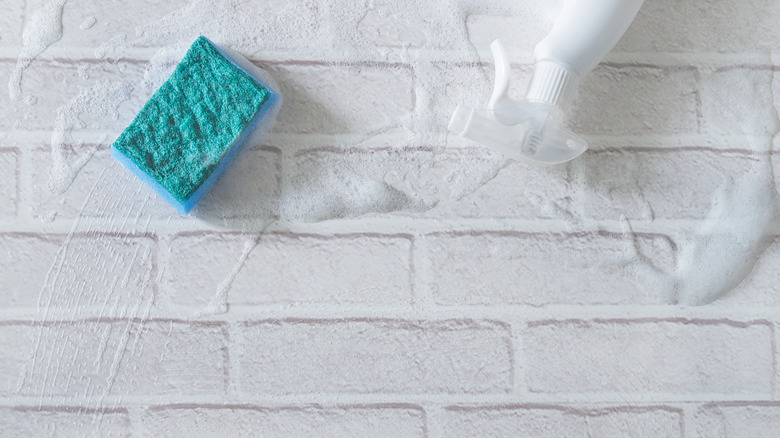 cleaning supplies and a white brick wall