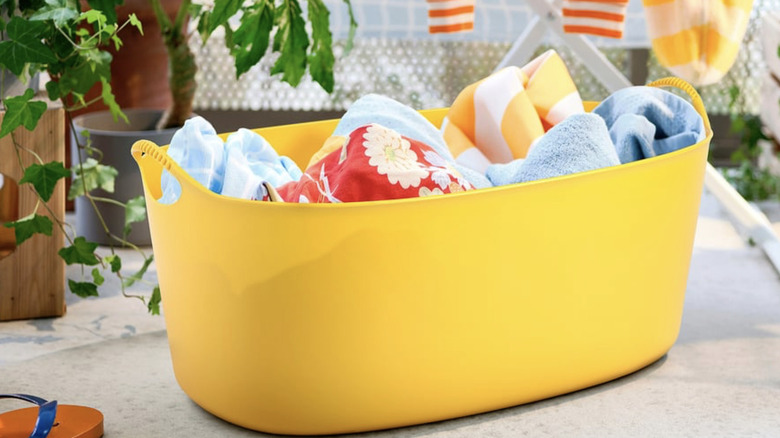 IKEA TORKIS laundry basket in bright yellow with various colorful towels inside