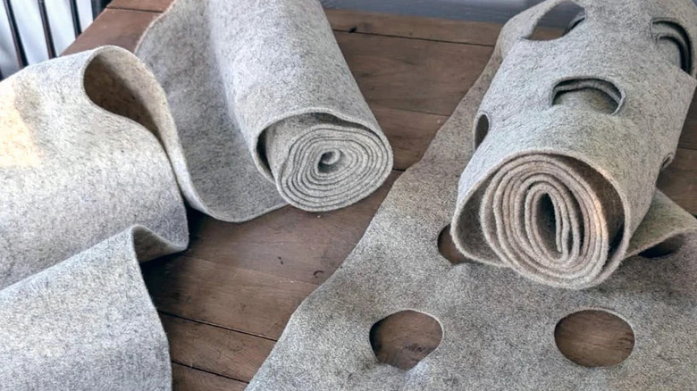 Rolls of wool landscape fabric with pre-cut holes for plants