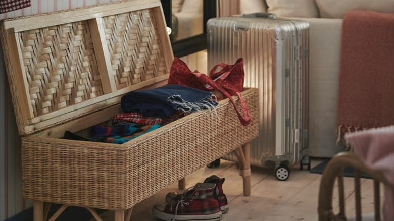 The TOLKNING Bench with storage with clothes stored in it and the lid up