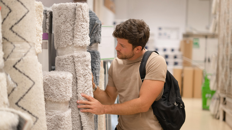 A man shopping for rugs