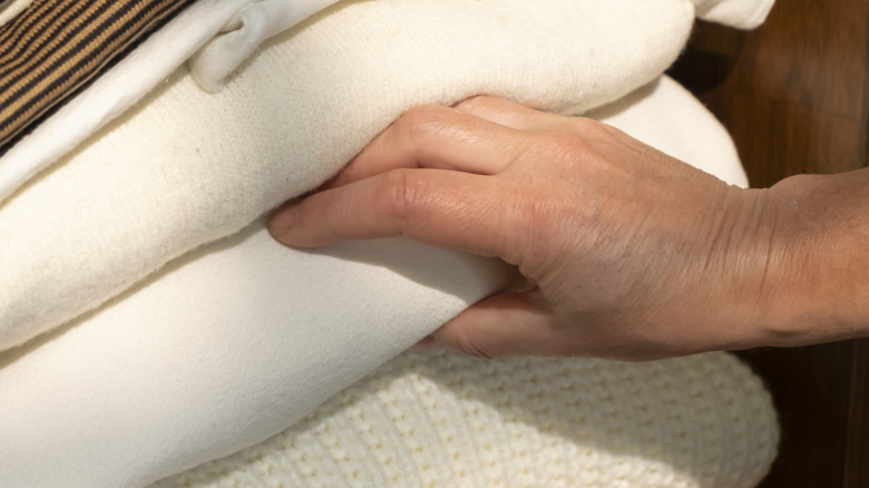 hand choosing between layers of blankets