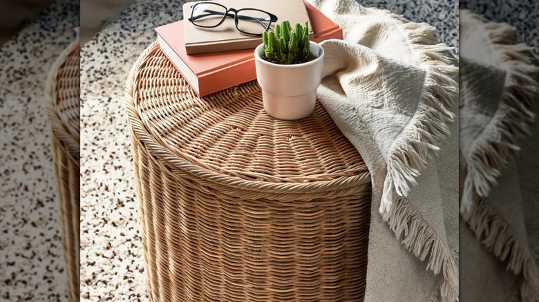 IKEA TOLKNING ottoman in living room setting with plant and blanket on top