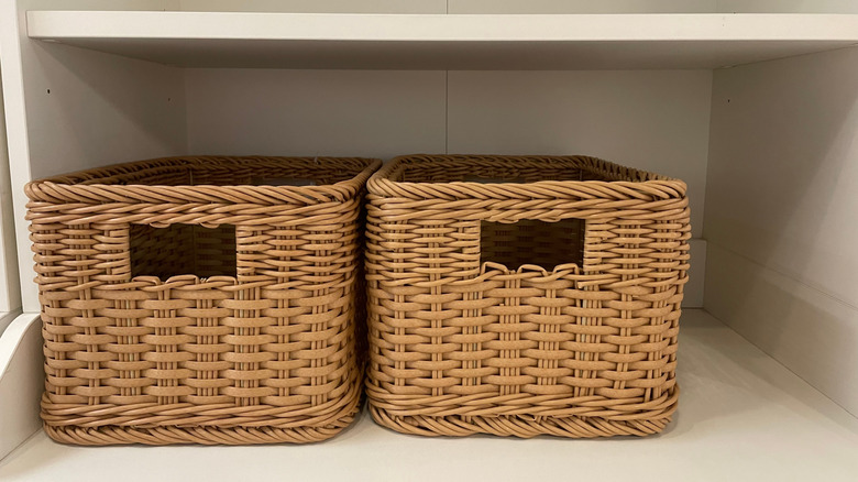 A shelf organized with wicker baskets
