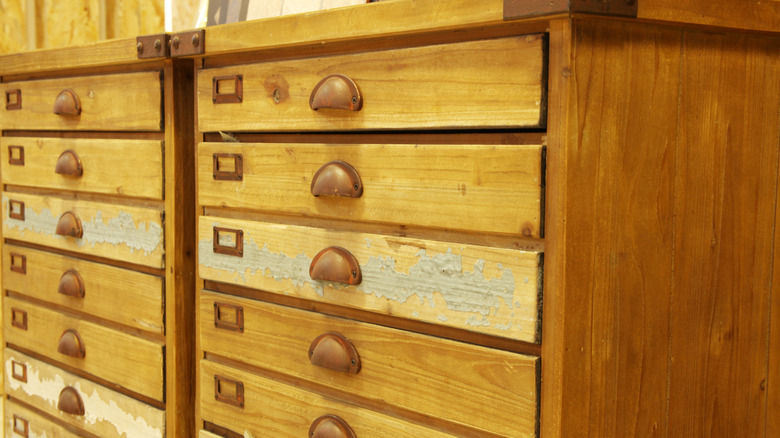 Close-up of an antique wooden drawer chest with shallow drawers