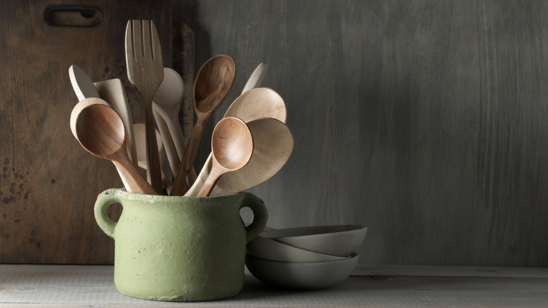 Kitchen utensils stored in an old ceramic pot