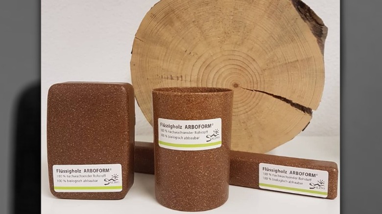 Arboform liquid wood composite cup, soap container, and toothbrush holder beside wood