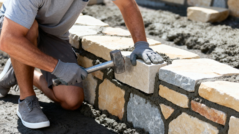 A man building a retaining wall