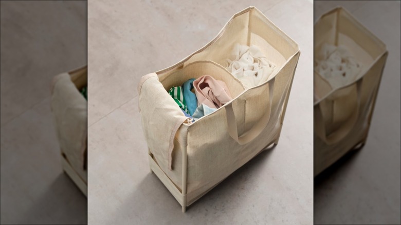 IKEA PURPLINGA beige laundry bag with laundry folded inside