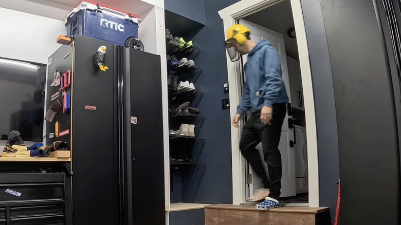 A DIY shoe closet in the corner of a garage