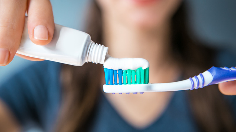 Toothpaste being applied to toothbrush