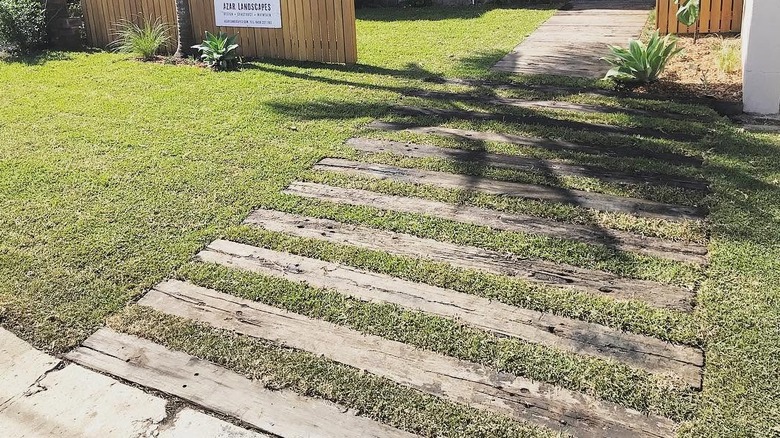 Railroad ties installed in grass landscaping as driveway