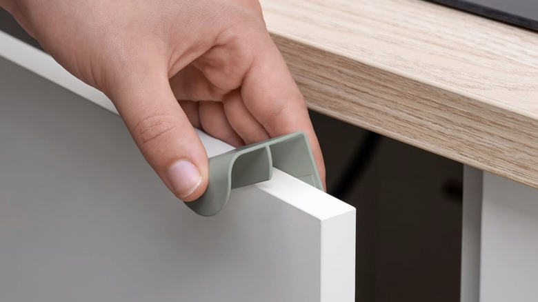DRAGSMARK clip-on handle being placed on cabinet door