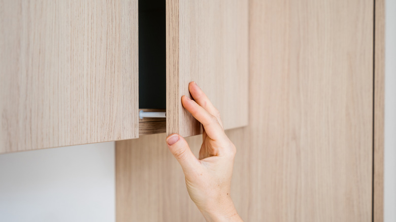 Hand opening cabinet without handle