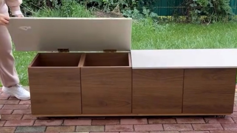 woman opening lid to DIY IKEA EKET storage cabinet
