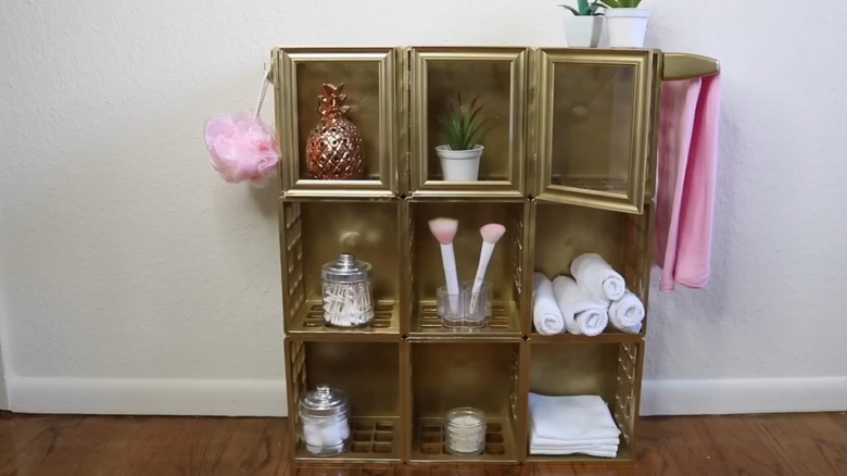The final design of a DIY bathroom cabinet made from mini plastic crates painted gold.
