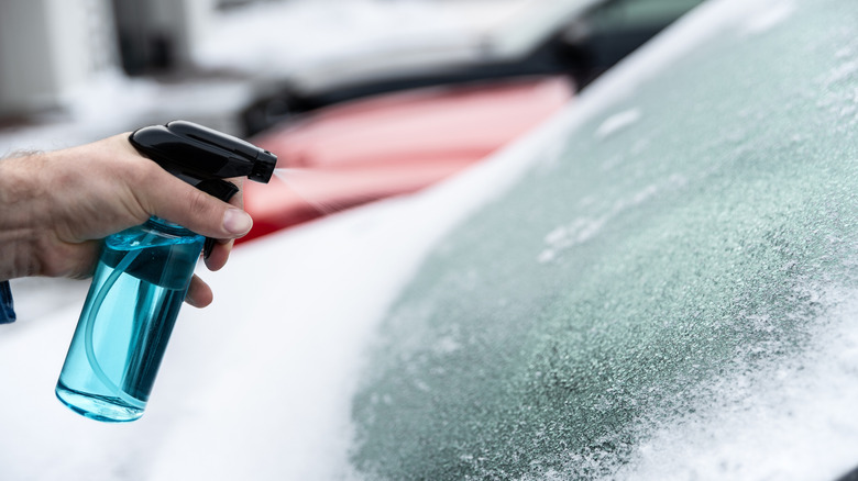 Spray bottle de-icing on windshield