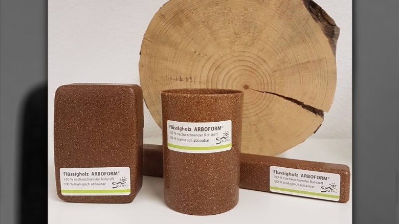 Arboform liquid wood composite cup, soap container, and toothbrush holder beside wood
