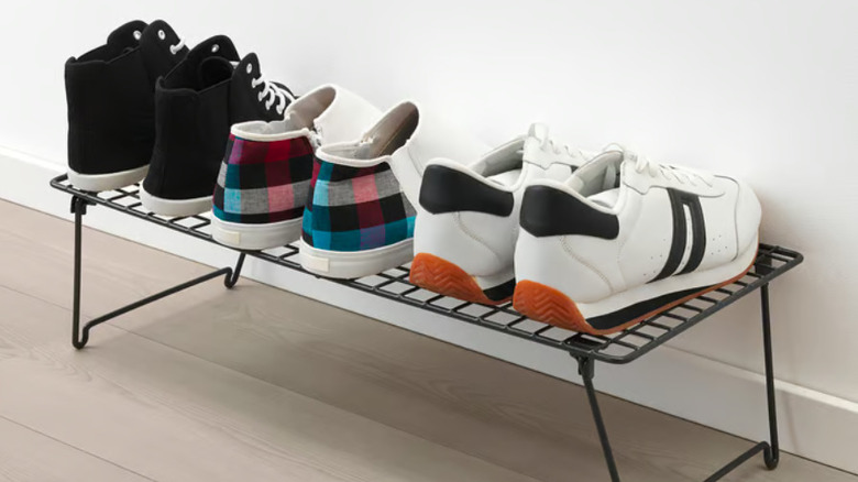 Shoes lined up on a metal rack.
