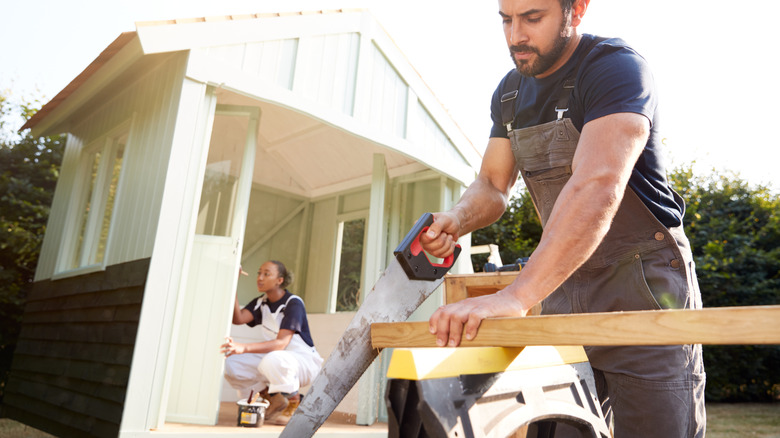 Couple working hard to build tool shed together