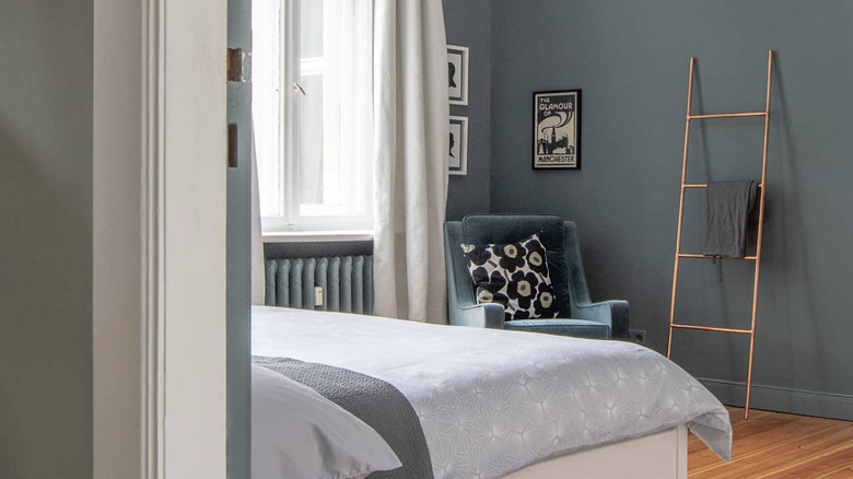 A copper towel ladder styled in a bedroom