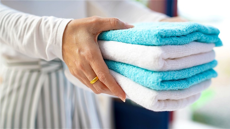 Person holding a stack of small washcloths