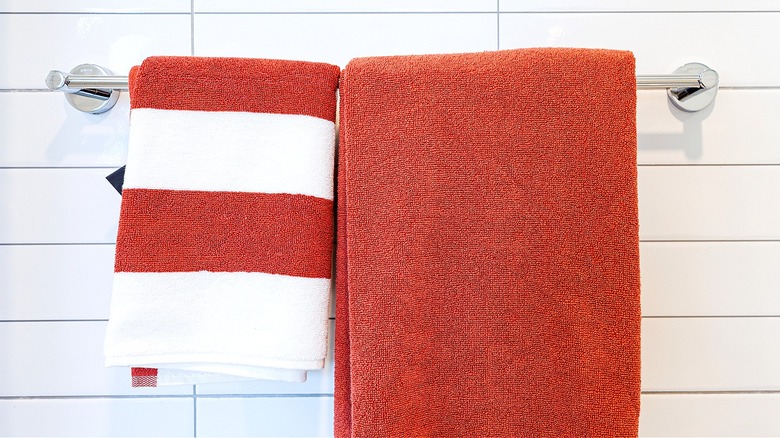 Two colorful towels are hanging from a towel rack in a bathroom