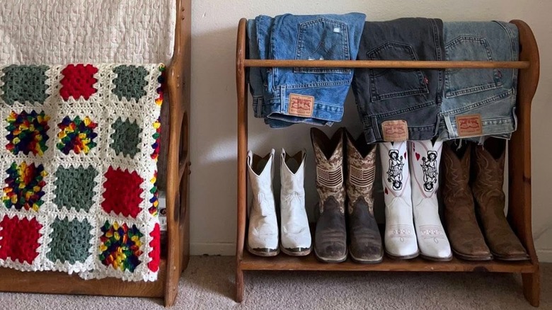 Vintage wooden quilt rack holding boots and jeans