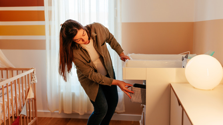 A woman organizing a nursery changing table station
