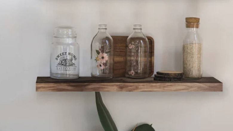 Floating acacia shelves with jars on them