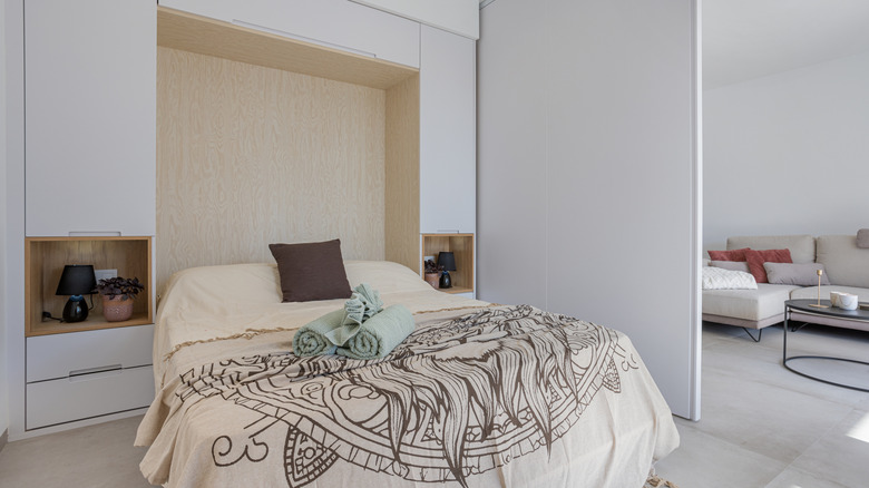 Sleek, modern bedroom with closed and open storage above bed