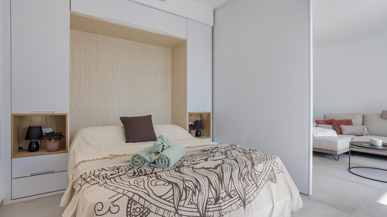 Sleek, modern bedroom with closed and open storage above bed