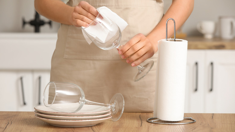 Woman drying glass with paper towel