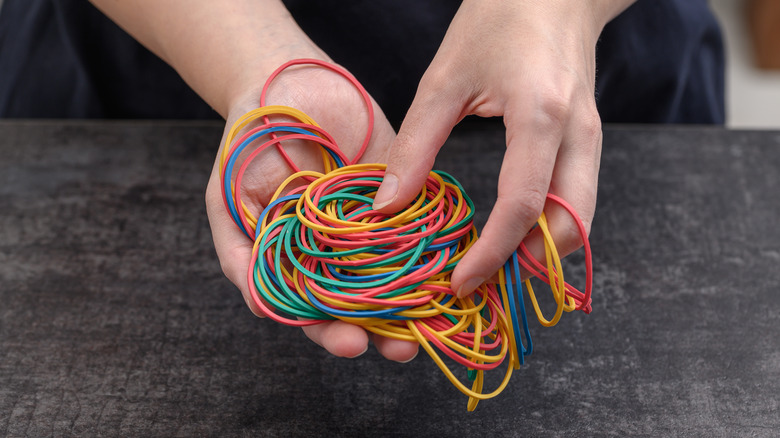 person holding rubber bands