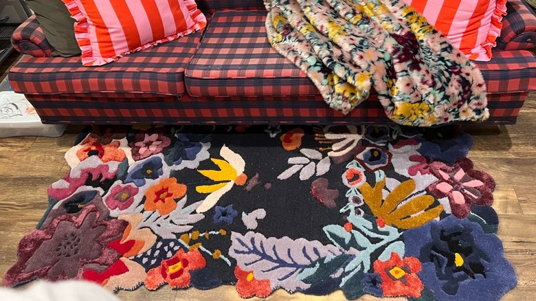 Reviewer's photo of rug styled in living room with colorful sofa