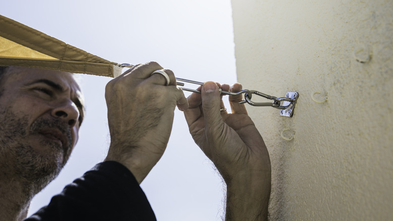 Man hanging up shade sail