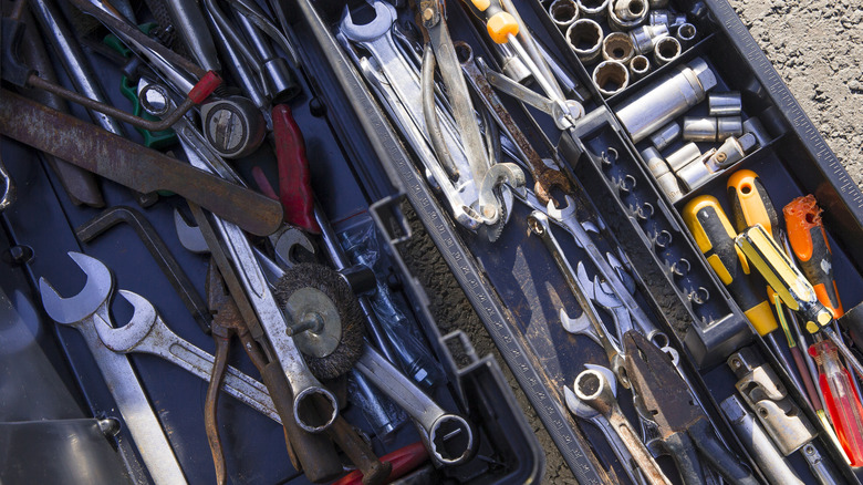 A traditional tool box with a disorganized collection of tools