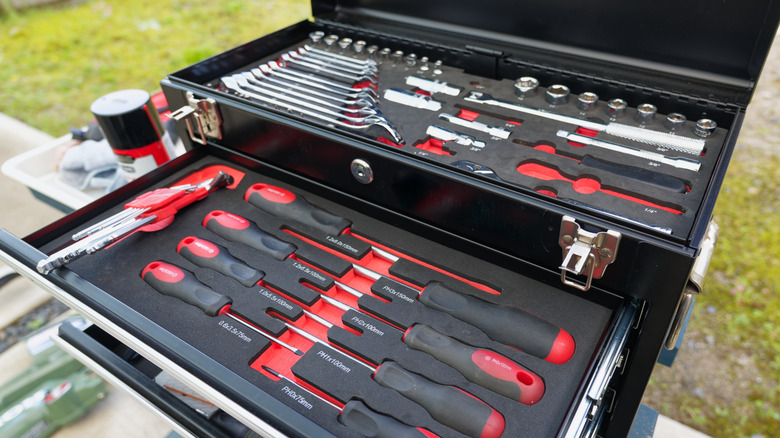 an open tool box with screwdrivers and sockets