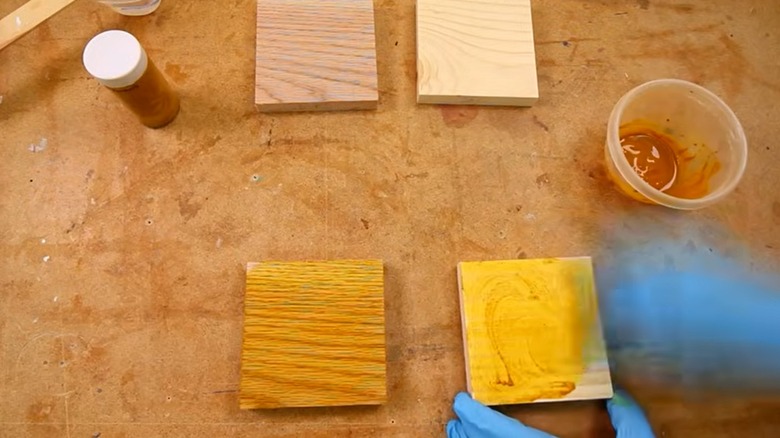 Person applying turmeric wood stain on wood